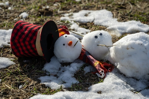 Melting snowman in spring sunlight symbolizing body weakness after winter